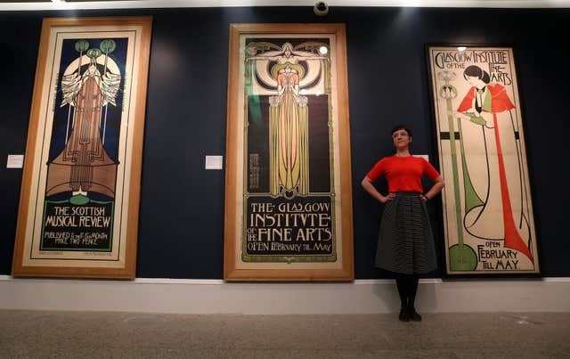 Assistant curator Hannah Willetts stands in front of posters at the launch of Charles Rennie Mackintosh Making the Glasgow Style (Andrew Milligan/PA)