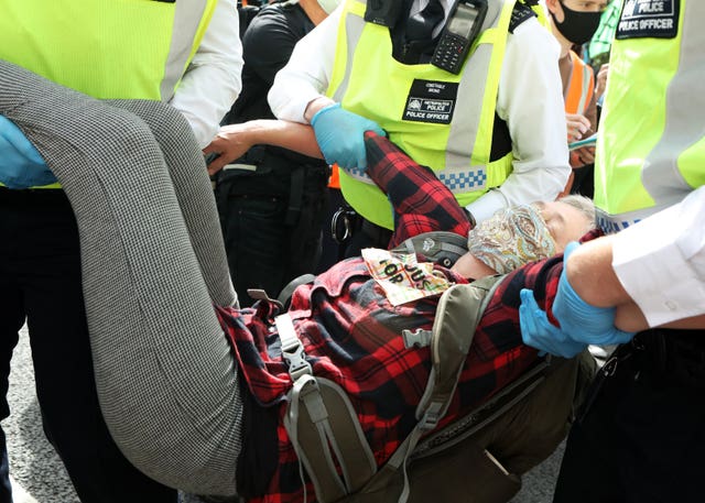 An Extinction Rebellion protester is removed by police officers near Parliament Square