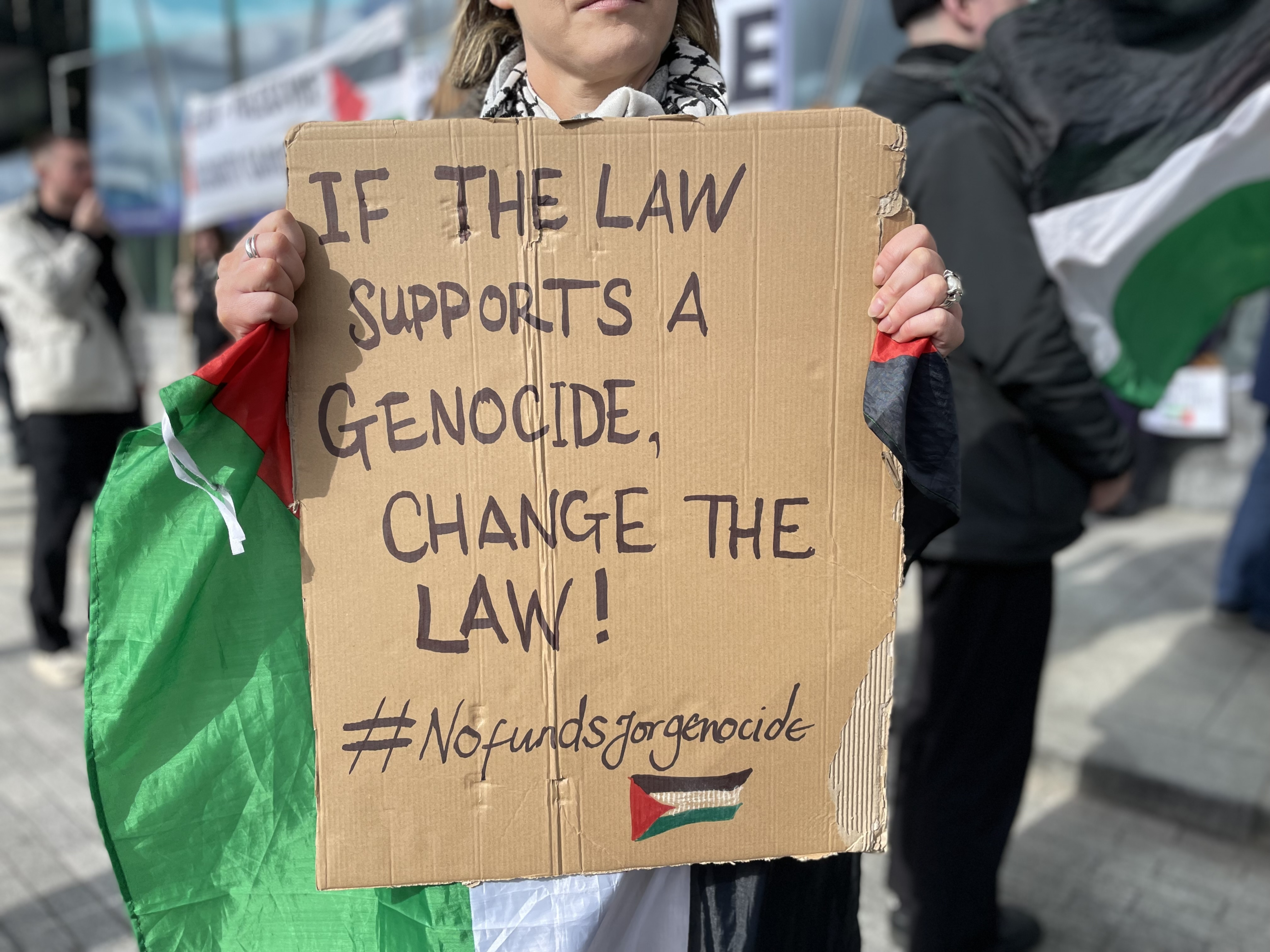 A protest sign reading 'If the law s a genocide, change the law'