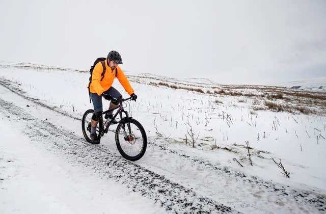 A cyclist out in the snowy conditions (Danny Lawson/PA)