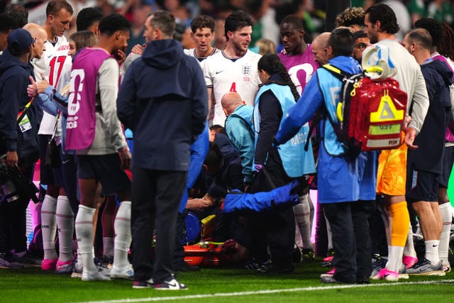 England’s Jordan Henderson is attended by medical staff and surrounded by team-mates after falling amid victory celebrations