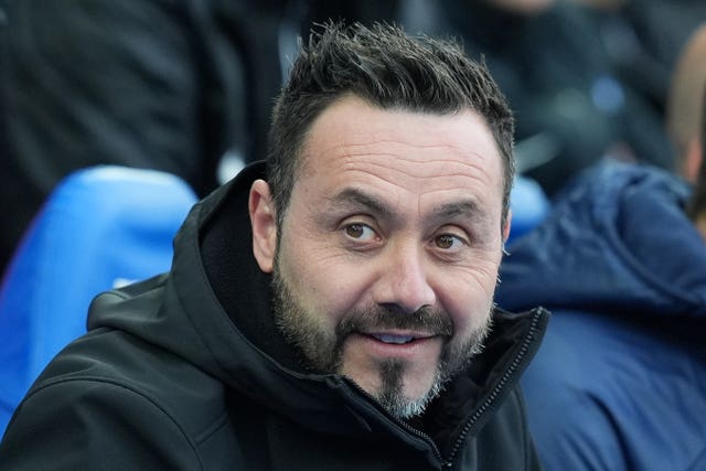 Roberto De Zerbi smiles in the Brighton dugout