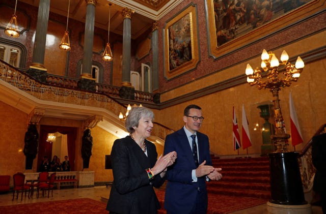 Theresa May and Mateusz Morawiecki applaud after hearing a choir sing during the consultations at Lancaster House