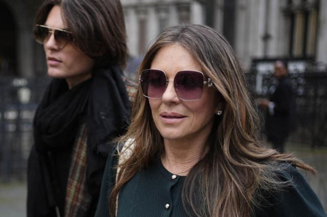 Hurley leaving the Royal Courts of Justice with her son Damian during the trial (Jordan Pettitt/PA)
