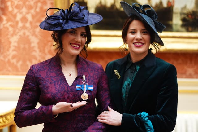 Georgia Laurie with her sister, Melissa, wearing the medal she received from the King