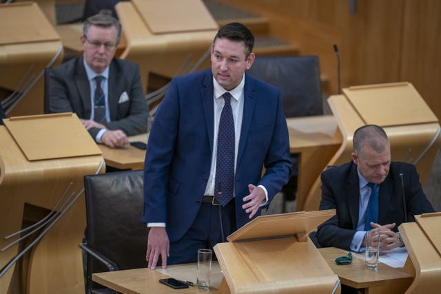 Miles Briggs standing while speaking in Holyrood