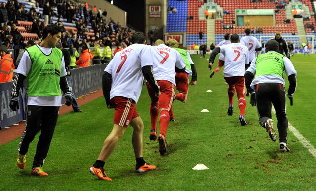 Liverpool players wear t-shirts with the name of Luis Suarez ahead of the game with Wigan