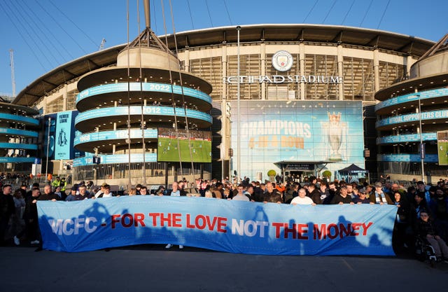 Manchester City fans hold a banner in protest of ticket reselling outside the Etihad Stadium