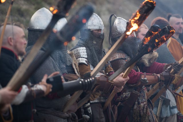 Re-eanctors prepare to burn a longboat