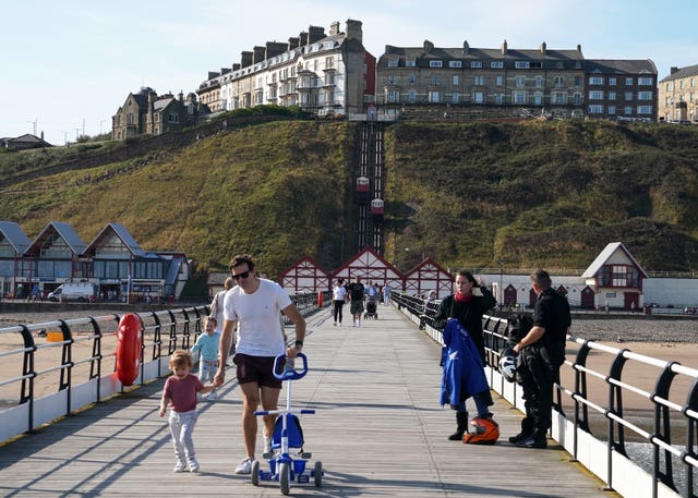 People enjoy the warm weather on the pier at Saltburn-by-the-Sea, North Yorkshire