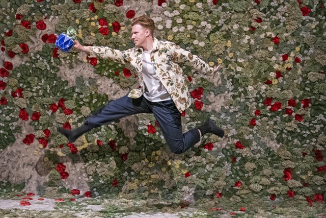 Designer Andrew Flynn jumps in front of a floral design
