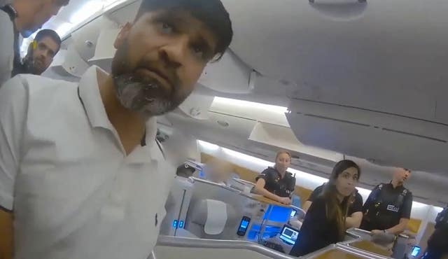 Urfan Sharif being detained on a plane