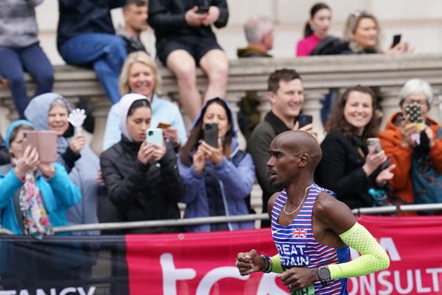 Onlookers take photos as Sir Mo Farah passes