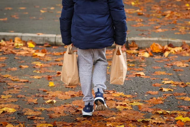 A child collects packed lunch bags