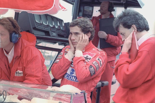Ayrton Senna, centre, shields his ears from the engine noise during the testing session at Silverstone
