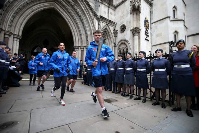 Aircraftsman Adam Wood, 16, (centre) runs with the RAF100 Baton (Steven Paston/PA)