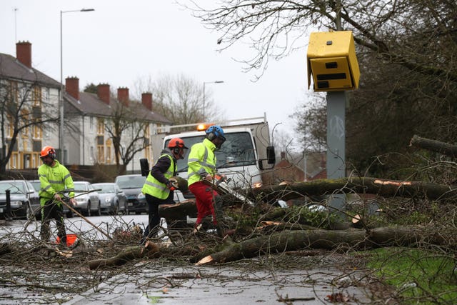 Workmen clear up after a tree fell on a speed camera on the Meadway in Tilehurst, Reading