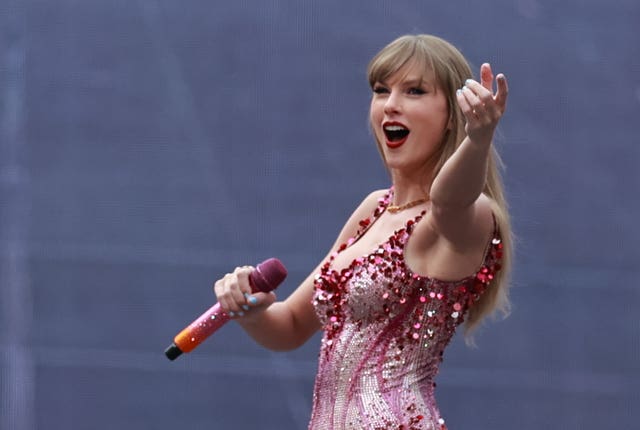 Taylor Swift performing in a pink sequined bodysuit