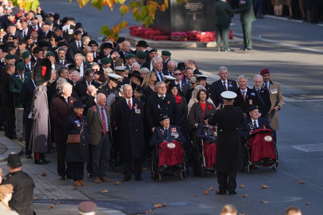 A procession of veterans, led by three in wheelchairs