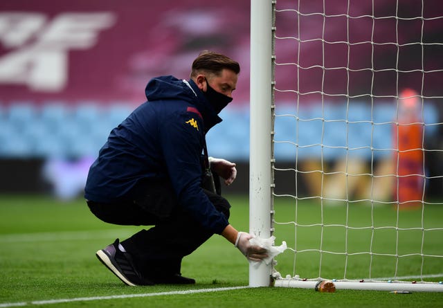 Goal posts are wiped clean with a disinfectant wipe ahead of the match at Villa Park 