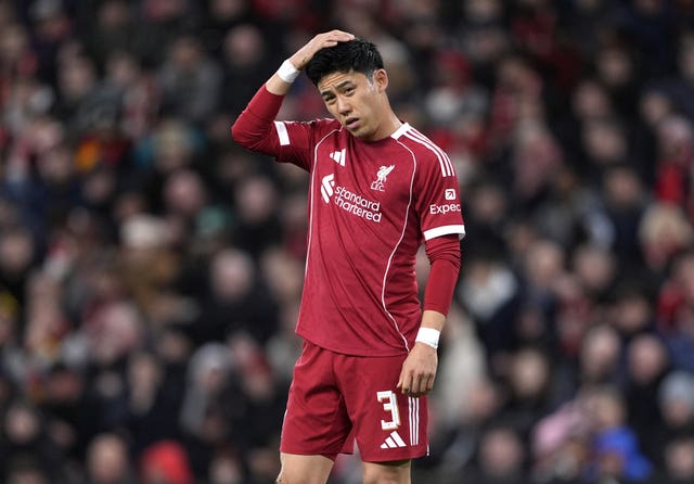 Liverpool midfielder Wataru Endo stands with his right hand on his head
