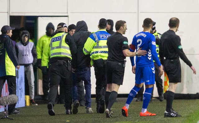 Rangers James Tavernier is pulled away from a fan that ran on to the pitch at Hibernian