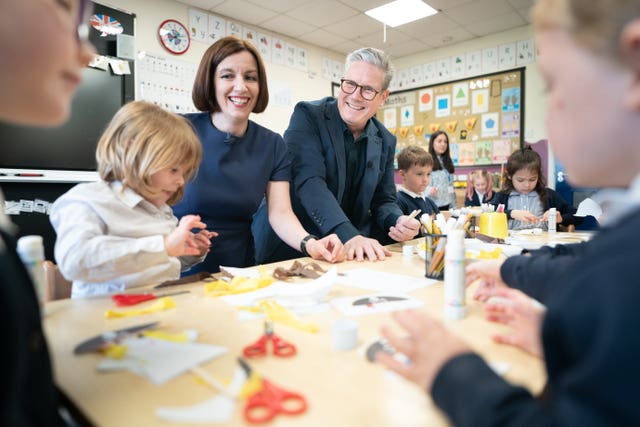Sir Keir Starmer and shadow education secretary Bridget Phillipson sit round a table with primary school pupils