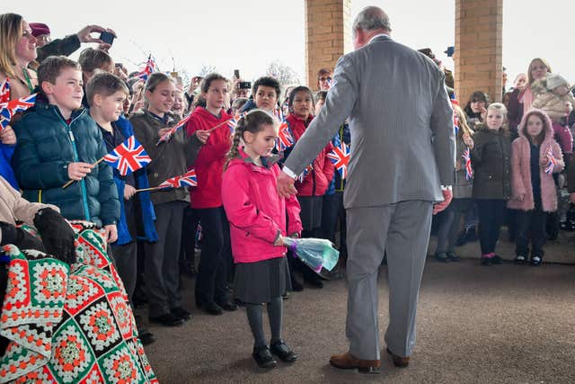 Bella Armstrong, 6, from Innsworth, offers the Prince of Wales flowers (Ben Birchall/PA)