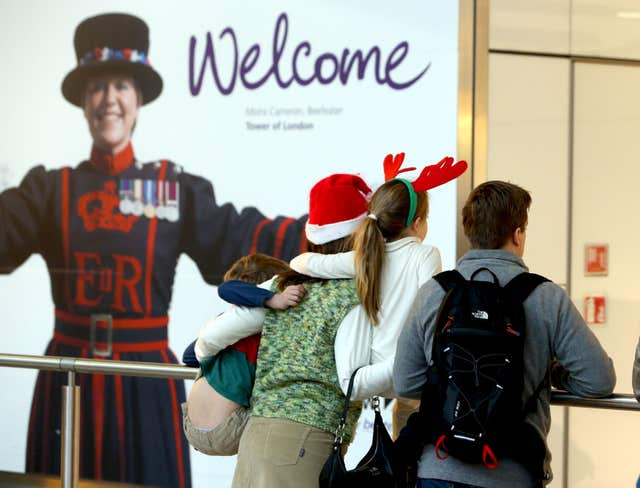 Families wait in arrivals of Terminal 5 at Heathrow Airport