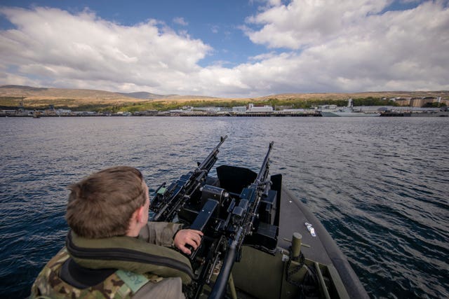 A Royal Marine patrols the waters at HMNB Clyde, which is the home of HMS Vigilant, the Vanguard-class submarine carries the UK’s Trident nuclear deterrent