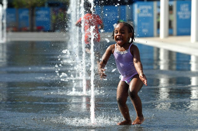 Two-year-old Luna Eddy plays in the water feature at Centenary Square, Birmingham