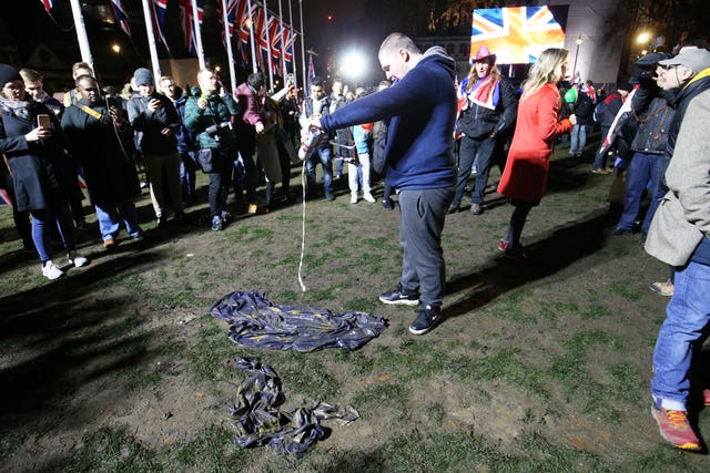 A pro-Brexit supporter pours beer onto an EU flag in Parliament Square