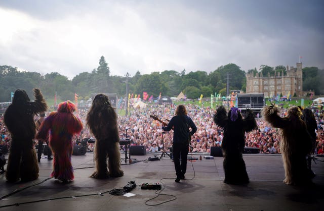 People dressed as Wookies on stage with Chesney Hawkes seen from behind
