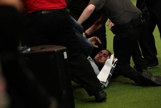 An intruder is wrestled to the ground after Tease, the Whippet, was named Supreme Champion