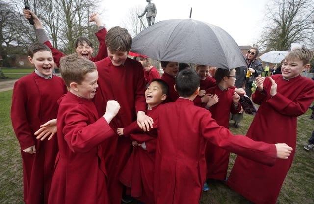 Boy choristers of Winchester Cathedral celebrate after one of their teams wins the Shrove Tuesday pancake race at Winchester Cathedral