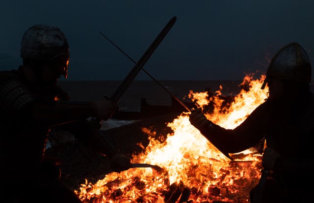 Re-enactor looks on as longboat burns