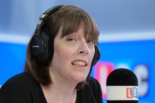 Jess Phillips speaking into an LBC microphone, wearing headphones