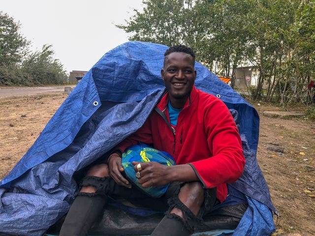Osiama Mike outside his tent