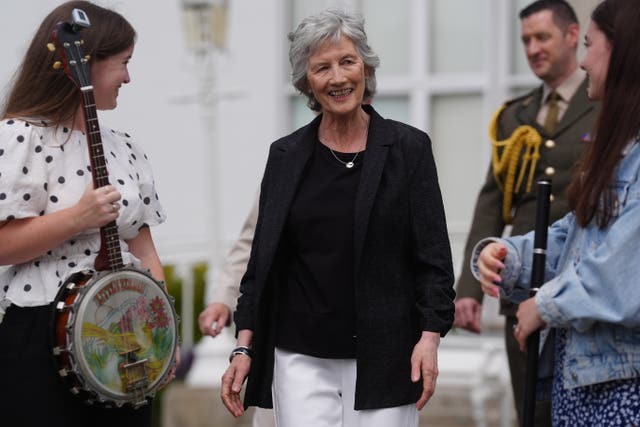 Catherine Connolly walking with musicians either side of her