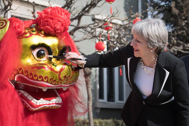 The PM 'dots the eye' of a Chinese dragon in the grounds of the British Embassy