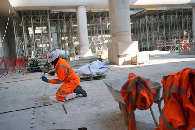A worker removing caps from the rebar couplers that were in the base slab,