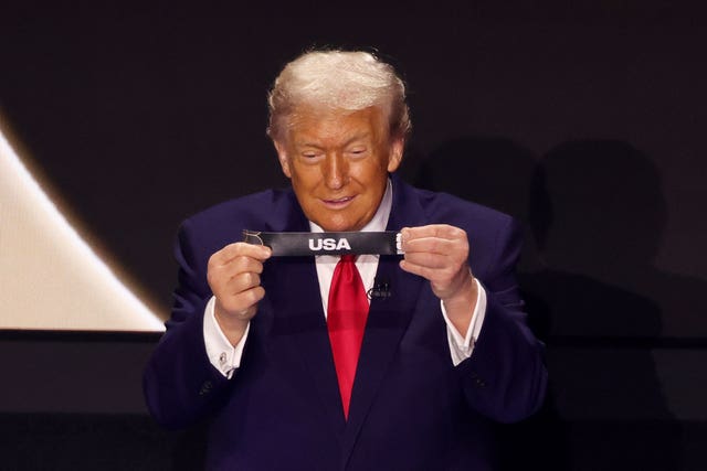 Donald Trump holding up the letters 'USA' on a small piece of paper after drawing his country in the 2026 Fifa World Cup draw