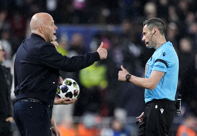Liverpool manager Arne Slot in discussion with referee Maurizio Mariani, right