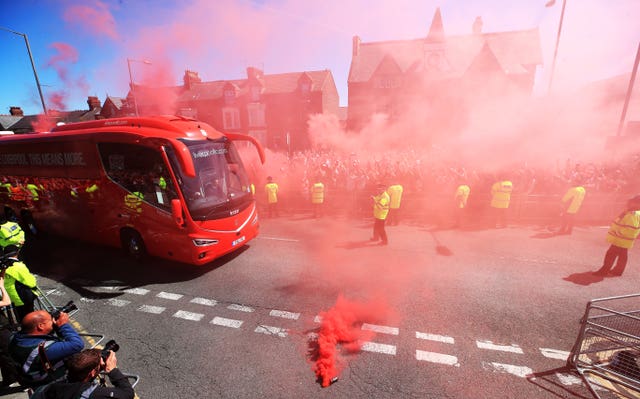 Liverpool fans welcome their team's bus to Anfield before their final game of the Premier League season