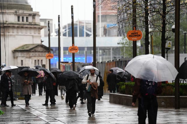 People in Birmingham hold umbrellas during wet and windy weather