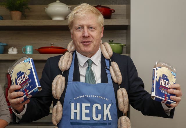 Boris Johnson holds up packs of ‘Boris Bangers’ during a visit to Heck Foods headquarters near Bedale in North Yorkshire
