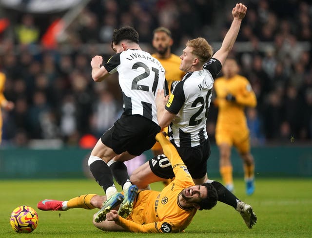 Newcastle’s Tino Livramento, left, and Lewis Hall, right, collide with Wolves’ Goncalo Guedes