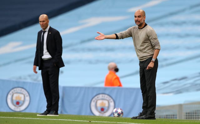 Pep Guardiola gestures on the sideline, alongside Real Madrid manager Zinedine Zidane and a Champions League ball