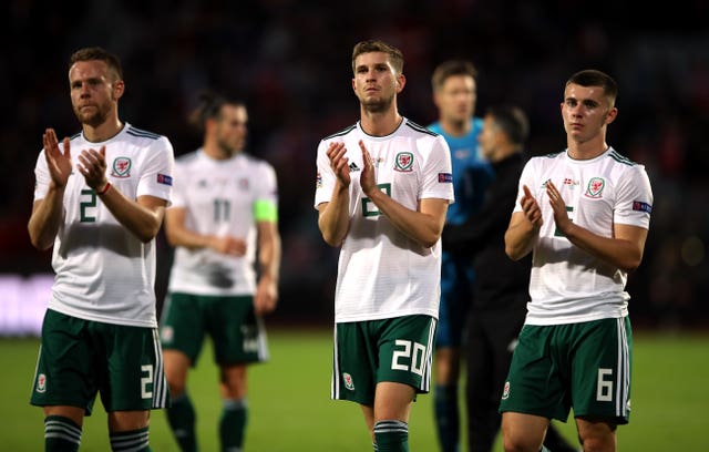 Wales’ (left-right) Chris Gunter, Chris Mepham and Ben Woodburn applaud the fans after the defeat in Belgium (Tim Goode/PA).
