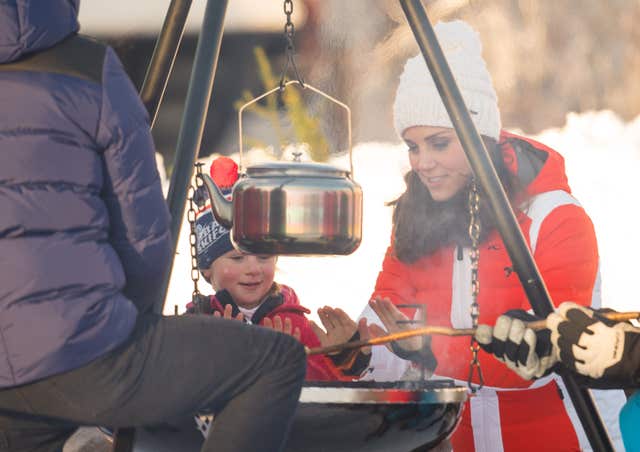 The Duchess of Cambridge warms her hands on a camp fire as she attends an event in Tryvann, Oslo, Norway, organised by the Norwegian Ski Federation, where she and the Duke of Cambridge saw a group of local nursery children taking part in an afternoon ski school session on the slopes, on the final day of their tour of Scandinavia (Dominic Lipinski/PA)